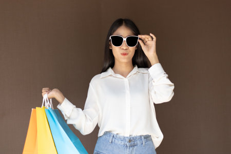 Text input box, Brown background, Young women carrying colorful shopping bags, Happy to buy products concept.の写真素材