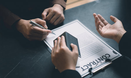 Real estate agent or sales manager has proposed terms and conditions to customers who sign house purchase agreements with insurance, Agreement to sign the purchase contract concept.の写真素材