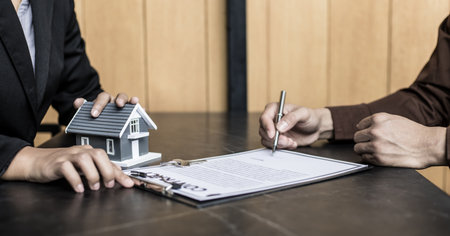 Real estate agent or sales manager has proposed terms and conditions to customers who sign house purchase agreements with insurance, Agreement to sign the purchase contract concept.の写真素材