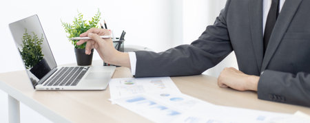 Financial or accounting professionals use a computer to analyze the company's revenue-expenses graph to prepare for presentation to the chief executive and partner, businessmen working in the room concept.の写真素材