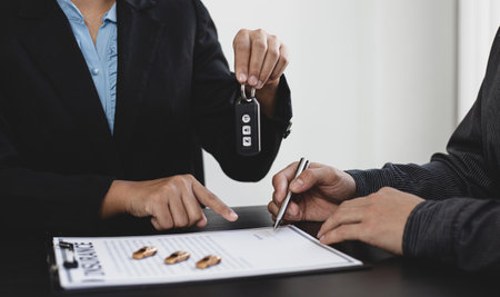 Car dealer or manager gives the keys to the customers who sign the car purchase documents with insurance, Document signing and credit approval Concept.の写真素材