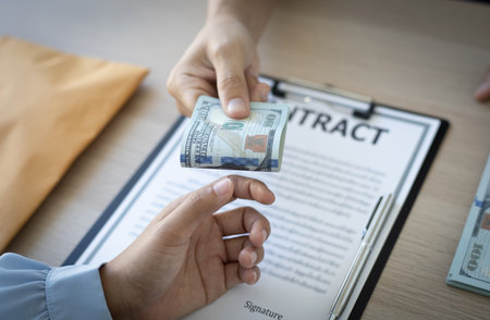 Businessmen give dollars to bribe employees in signing contracts to buy illegal land and real estate, Business fraud and social injustice, corruption and bribery concept.の写真素材