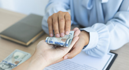 Businessmen give dollars to bribe employees in signing contracts to buy illegal land and real estate, Business fraud and social injustice, corruption and bribery concept.の写真素材
