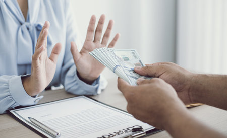 Businessmen give dollars to bribe employees in signing contracts to buy illegal land and real estate, Business fraud and social injustice, Anti Bribery and corruption concept.の写真素材