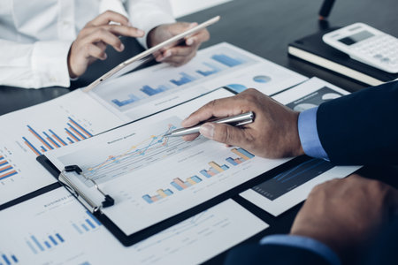 Brainstorm team, Marketers and financial accountants are discussing and analyzing charts to plan strategies to meet customer needs, Tablet technology for business concept.の写真素材