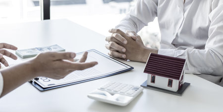 Real estate broker agents advise clients to make a decision to buy a house with insurance. Negotiating purchase-sale and investment planning concept.の写真素材