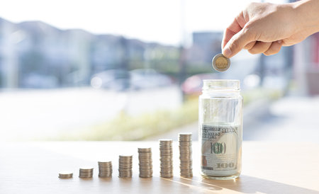 Businessman putting money on stacking coin that shows a graph the financial growth profit of...