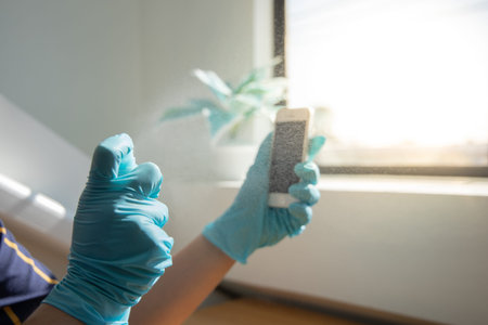 Close up young Asian man's hand is spraying an alcohol spray to kill germs on smartphones, Initial protection against germs, Cleaning of electronic appliances or disinfectants during an epidemic.の写真素材