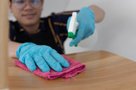Close up employees' hands were wiping the chairs to clean after the customers finished their meal, Using cleaning solutions or using alcohol to kill germs in the restaurant.の写真素材
