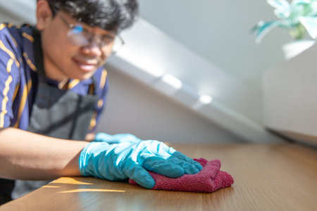 Close up Staff hand Restaurant workers are cleaning table and spraying disinfectants during the virus outbreak, Using cleaning solutions or using alcohol to kill germs in the restaurant.の写真素材