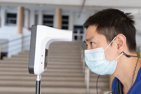 Man approached the forehead thermometer sensor to detect body heat,Temperature measurement points...