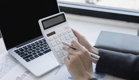 Accounting businesswomen are calculating income-expenditure and analyzing real estate investment data, Dedicated to the progress and growth of the company, Financial and tax systems concept.の写真素材