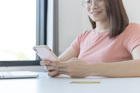 Close-up image of woman's hand holding a phone or smartphone For internet and entertainment or to relax after working in the office, Technology communication and internet networking.の写真素材