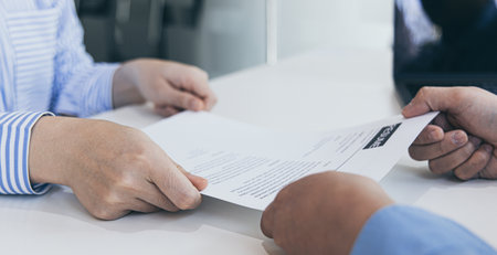 Applicants submitting a resume to the staff to apply for a job, Participating in the selection of applicants to work in the company, Submitting documents or submitting a resume.の写真素材