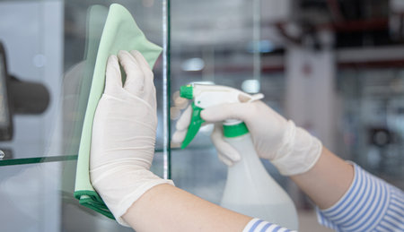 Cleaning staff operator injects alcohol and Use a cloth to wipe the window or glass, Cleaning windows with antiseptic or virus remover, Prevention of accumulated pathogens, Spread of virusの写真素材