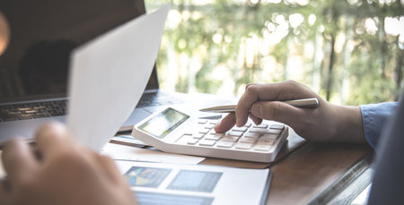 Accounting businessmen are calculating income-expenditure and analyzing real estate investment data, Dedicated to the progress and growth of the company, Financial and tax systems concept.の写真素材