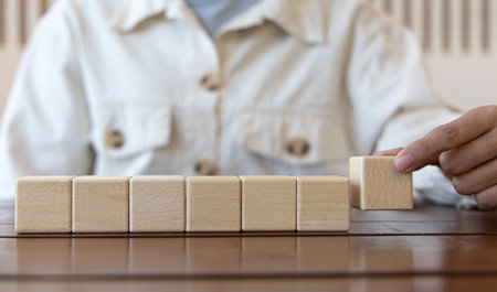 Arrange the wooden blocks into steps, higher the marketing strategy the more effort is required, Ladder of success, Driving business at the peak concept.の写真素材