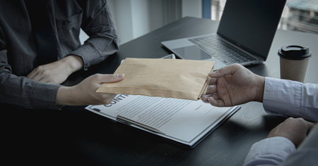 Anti corruption ,Businessmen give illegal or corrupt bribes in brown envelopes to employees to approve projects, Evil planning and illegal activities.の写真素材