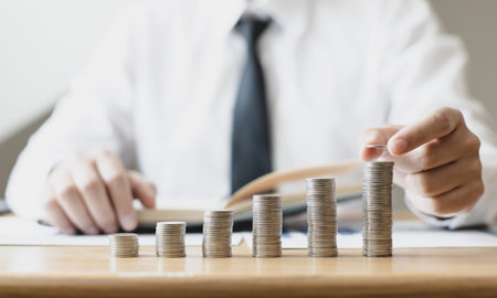 Man's hands put the coins arranged in steps, Managing your finances or saving money for future use,...