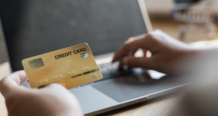 Woman's finger presses a keyboard and holds a credit card to register for payment or online transactions, Financial transactions and Internet security, Shopping online and banking online concept.の写真素材