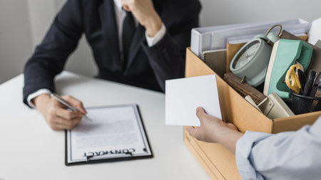 Employee handed over a document envelope and a box of work equipment beside him, Woman submits...