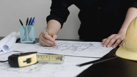 Architectural building design and construction plans with blueprints, Young man was designing a...