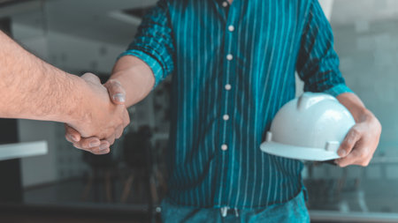Men shake hands after the deal is done, Architects and engineers join hands to congratulate them after the building site meeting is completed, Symbol of friendship in business of both parties.の写真素材