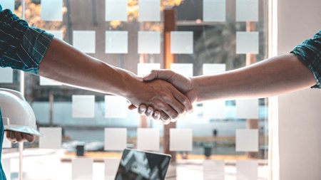Men shake hands after the deal is done, Architects and engineers join hands to congratulate them after the building site meeting is completed, Symbol of friendship in business of both parties.の写真素材