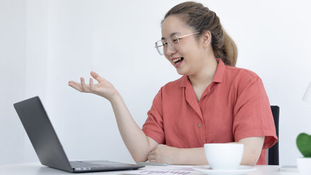 Young Asian women are greeting friends and teachers through video chats and greeting them with cheerful expressions, Online communication , Stay homeの写真素材