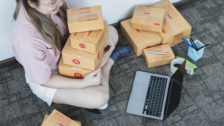 Young woman was happy after receiving an order from an internet customer, New business style for young people working at home and owning businesses, Sell online or Online sell concept.の写真素材