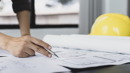 Architectural building design and construction plans with blueprints, Young man was designing a...