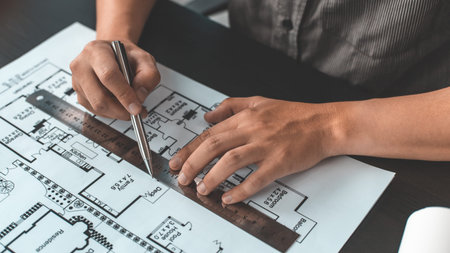 Engineer and Architect concept, Man uses a ruler to measure the floor plan on the blueprint,...