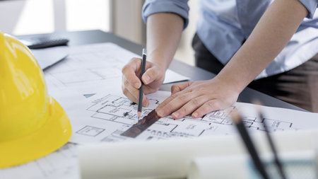 Engineer and Architect concept, Man uses a ruler to measure the floor plan on the blueprint,...