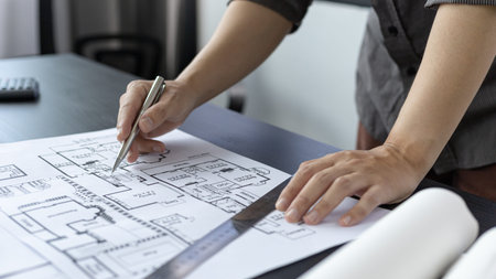 Architectural building design and construction plans with blueprints, Young man was designing a...