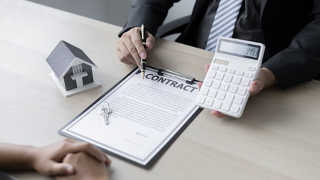 Real estate agent or sales manager talks to clients about the terms of buying a home and collateral  including a free home insurance giveaway promotion, Offerings and Services concept.の写真素材