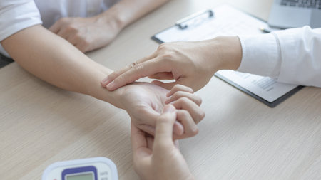 Medical professional measures the pulse of a male patient's wrist to check his heart rate in the hospital's examination room, Doctor checking patient health, Initial symptom check.の写真素材