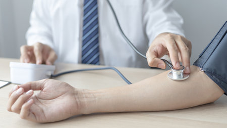 Man doctors use blood pressure monitors and stethoscope to measure pulse Diagnose the patient's disease in a modern hospital medical laboratory, Medical treatment and health check.の写真素材