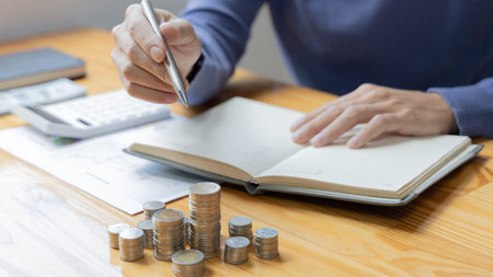 Men are taking notes on household income and expenses and working to save money for future use,...
