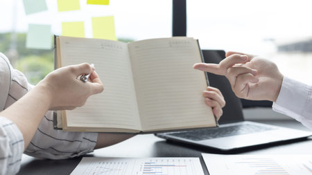 Blank notebook, Business text input area, Business men and women pointing to an empty area of a...