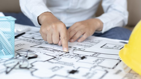 Architectural building design and construction plans with blueprints, Young man was designing a...
