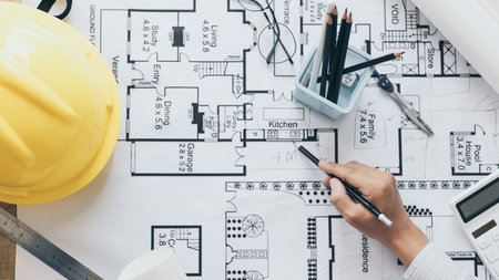 Architectural building design and construction plans with blueprints, Young man was designing a...