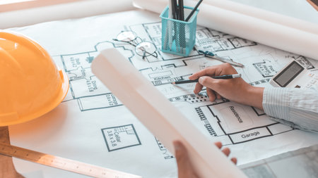 Architectural building design and construction plans with blueprints, Young man was designing a...