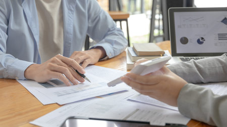 Brainstorm team, Marketers and financial accountants are discussing charts to plan strategies to meet customer needs, Using graphs to analyze business data, Meetings or business consulting.の写真素材