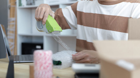 Man is packing in the mailbox to prepare to deliver it to the customer, Working at home and owning businesses, Online shopping SME entrepreneur, packing box, Sell online, freelance working.の写真素材