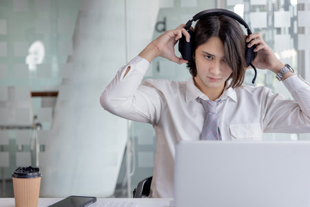 Businessman are greeting friends and manager through video chats and use headphones for communication and business conversations, Online communication, New normal, VDO Call, Internet learning.の写真素材