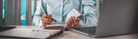 Young female student reading a book in a private office, Long distance education, Textbooks from...