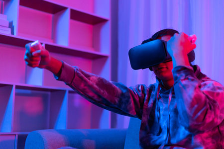 Man wears virtual reality glasses and uses joystick to play games with fun, VR, Future games,...