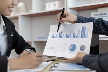 Brainstorm team, Marketers and financial accountants are discussing and analyzing charts to plan a...