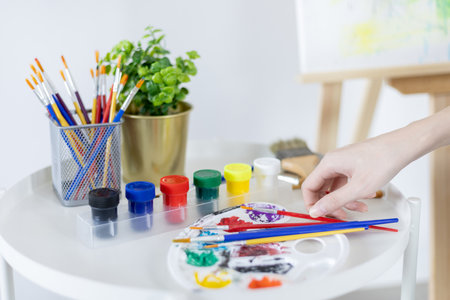 Female artist painting on canvas, Artist studio interior, Draw with watercolor, Drawing supplies , Painting and creativity, Use a brush to draw a pattern by stripes, Artwork, Using Paint Brush.の写真素材