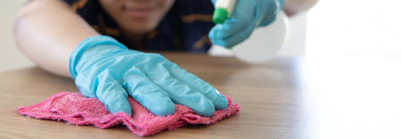Close up Staff hand Restaurant workers are cleaning table and spraying disinfectants during the virus outbreak, Using cleaning solutions or using alcohol to kill germs in the restaurant.の写真素材